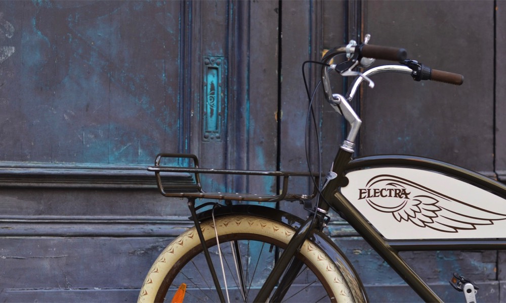 Electra Delivery voor een oude deur in Barcelona tijdens fietstour.